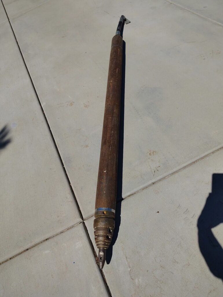 Heavy-duty curb coring drill on concrete surface for pavement cutting.